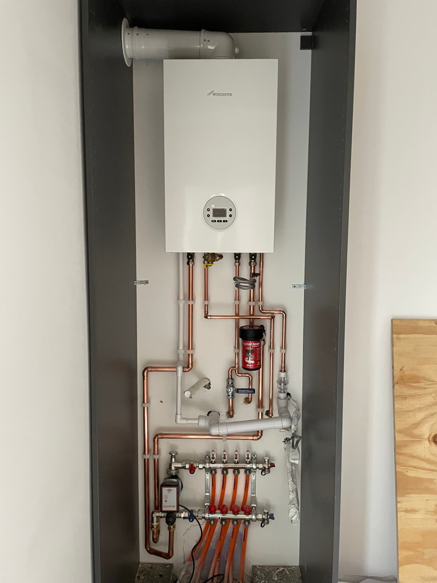 Worcester boiler, MagnaClean filter and underfloor heating manifold in a plant cupboard