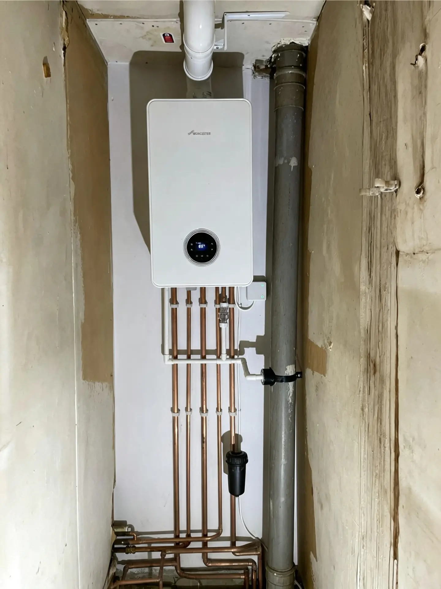 Worcester Bosch combi boiler fitted in a compact cupboard with copper pipework